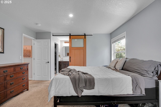1223 NE 160th Ave, Portland, OR 97230 - bedroom with a textured ceiling, light carpet, a barn door, and ensuite bathroom