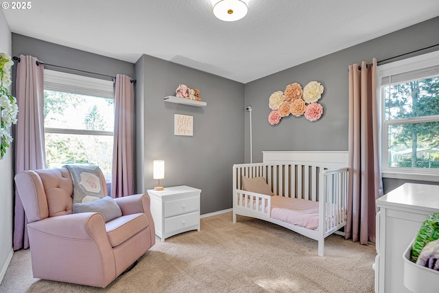 1223 NE 160th Ave, Portland, OR 97230 - bedroom with a crib, baseboards, light carpet, and a textured ceiling
