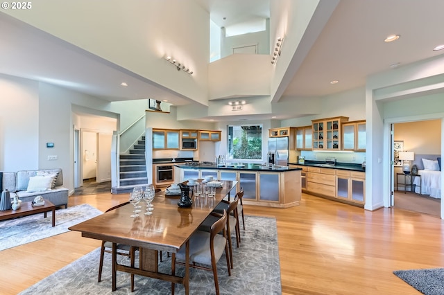4300 SW Hewett Blvd, Portland, OR 97221 - dining room featuring light wood-type flooring, stairway, and a high ceiling