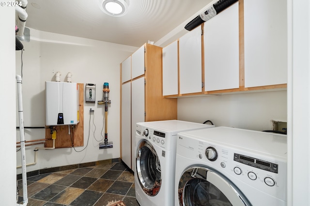 clothes washing area with water heater, independent washer and dryer, and cabinets