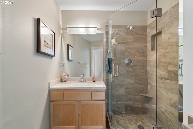 bathroom with vanity and a shower with door