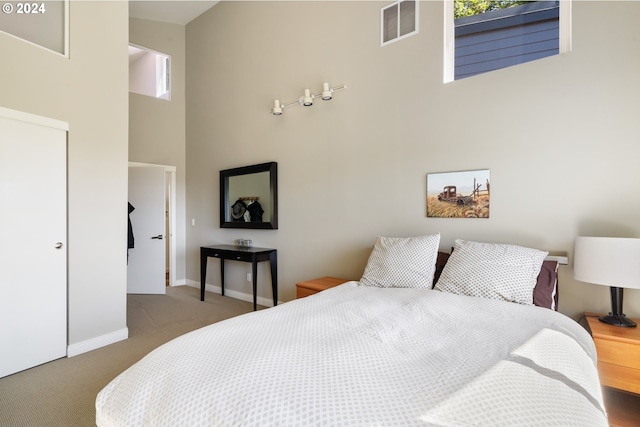 carpeted bedroom with a high ceiling