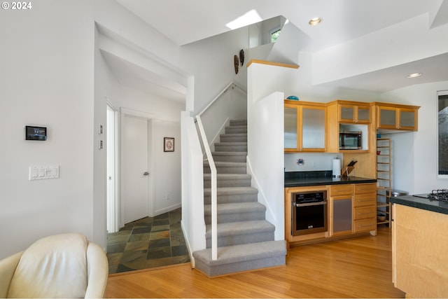 kitchen with appliances with stainless steel finishes and hardwood / wood-style floors