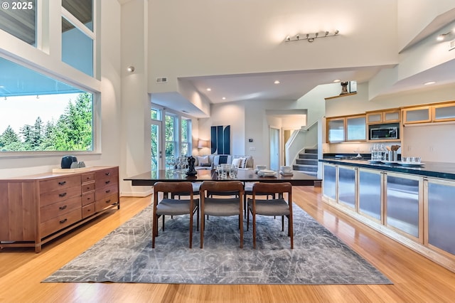 4300 SW Hewett Blvd, Portland, OR 97221 - dining area featuring stairway, light wood-style flooring, a high ceiling, and recessed lighting