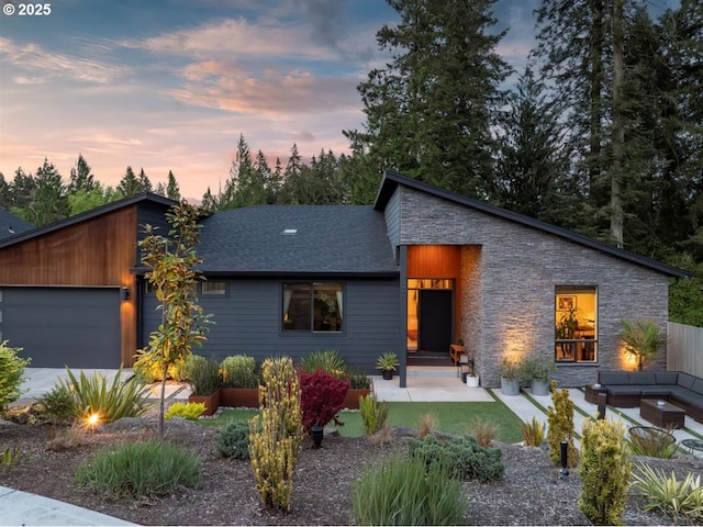 720 S 19th Pl, Ridgefield, WA 98642 - view of front facade with stone siding, an attached garage, a shingled roof, an outdoor hangout area, and a patio