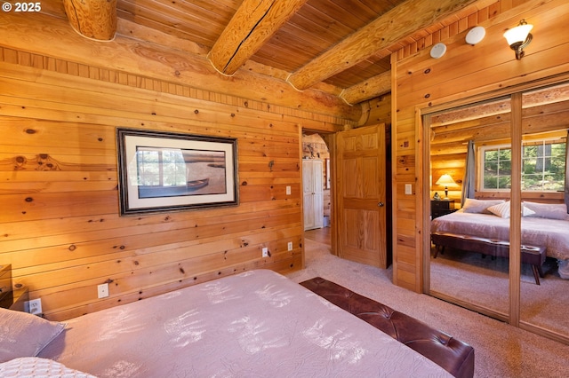 93011 Labeck Rd, Astoria, OR 97103 - carpeted bedroom with a wooden ceiling with exposed beams, rustic walls, wood walls, and a closet