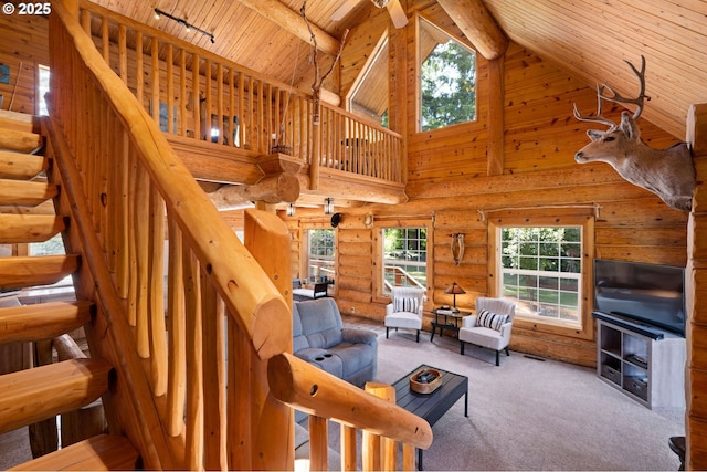 93011 Labeck Rd, Astoria, OR 97103 - carpeted living area featuring a wooden ceiling with exposed beams, high vaulted ceiling, stairway, rustic walls, and rail lighting