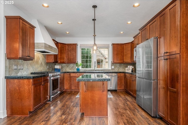 kitchen with a center island, premium range hood, dark stone counters, appliances with stainless steel finishes, and dark wood-style flooring