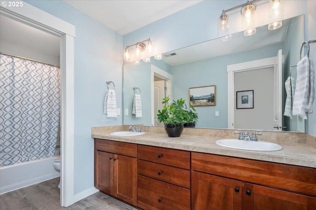 full bath featuring double vanity, visible vents, toilet, and a sink