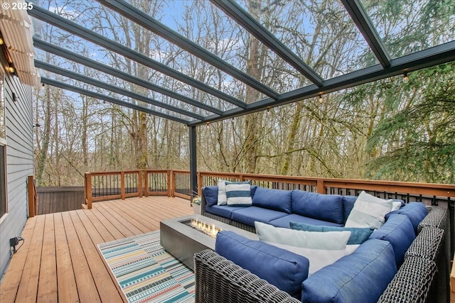 wooden terrace featuring an outdoor living space with a fire pit and a pergola