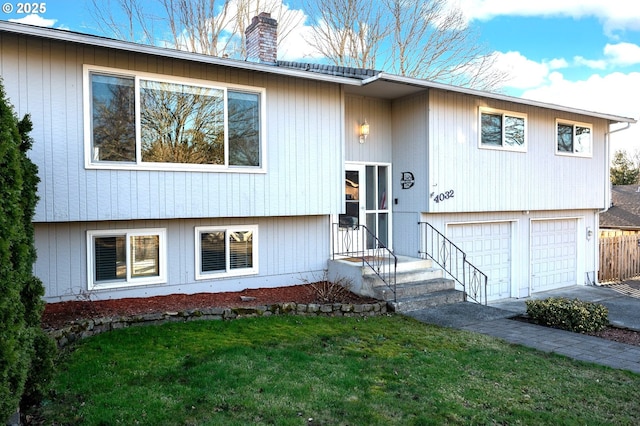 bi-level home with a garage and a front lawn