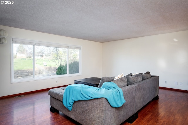 living room with dark hardwood / wood-style flooring and a textured ceiling