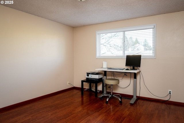 home office with dark wood-type flooring and a textured ceiling