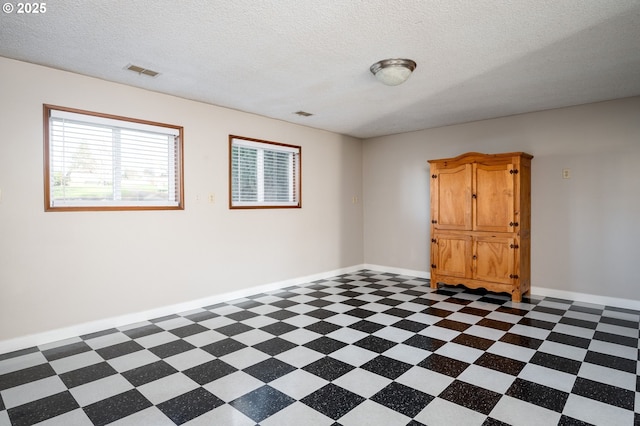 unfurnished room featuring a textured ceiling