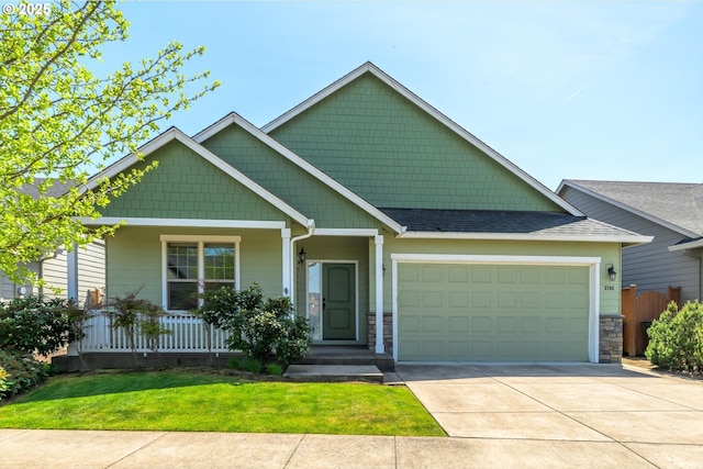 craftsman-style house with roof with shingles, an attached garage, a porch, a front yard, and concrete driveway