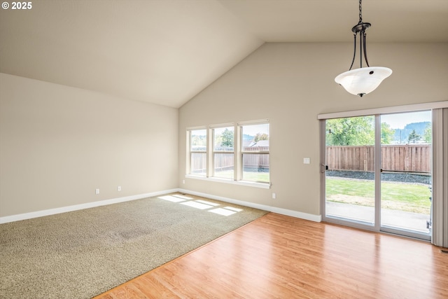 interior space with high vaulted ceiling, baseboards, and wood finished floors