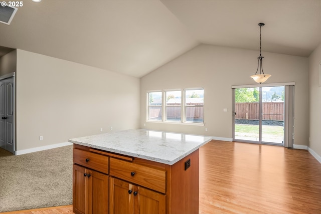 kitchen featuring light stone countertops, light wood-style floors, open floor plan, visible vents, and pendant lighting