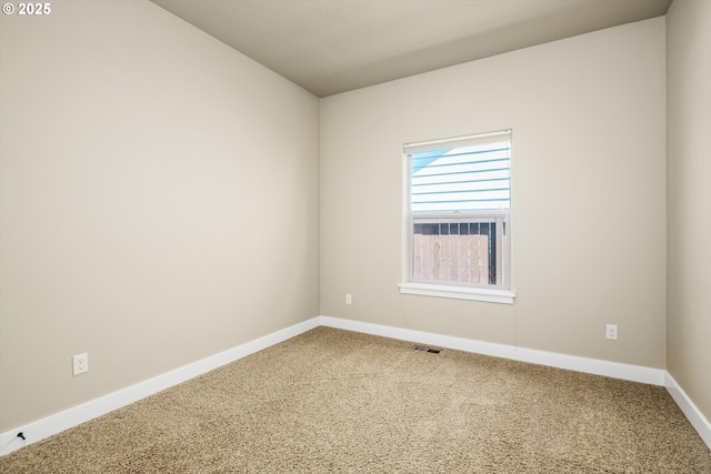 empty room featuring carpet floors, baseboards, and visible vents