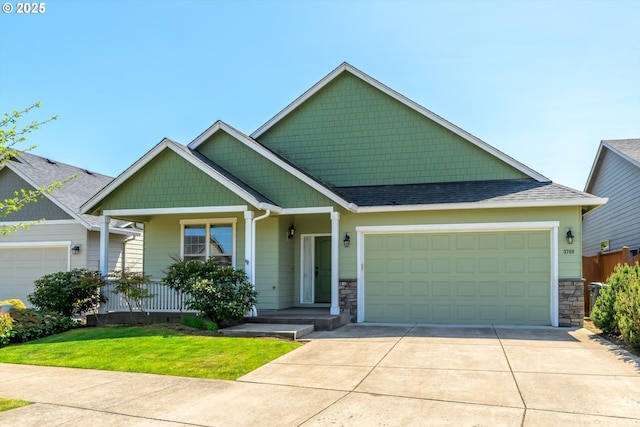 craftsman-style home with a front yard, stone siding, roof with shingles, an attached garage, and driveway