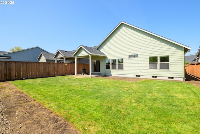 back of house featuring a fenced backyard, a patio area, and a yard