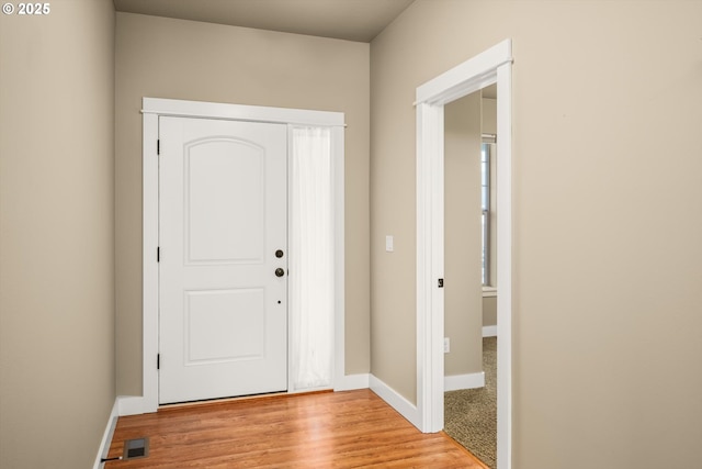 foyer with baseboards, visible vents, and light wood finished floors