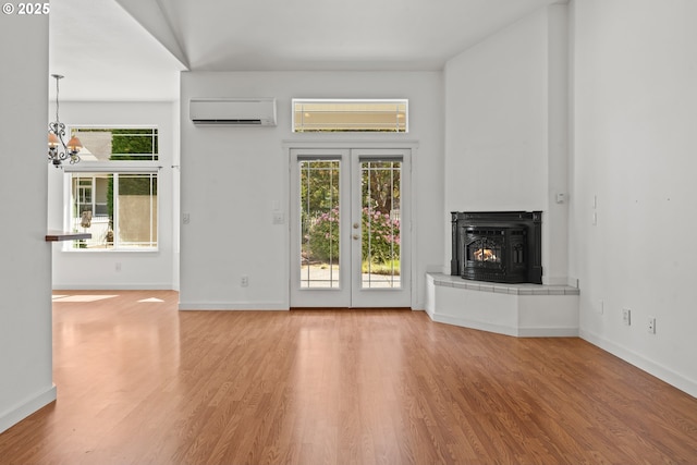 1249 Zebrawood St, Florence, OR 97439 - unfurnished living room with an AC wall unit, wood finished floors, french doors, and baseboards