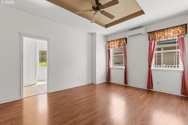 1249 Zebrawood St, Florence, OR 97439 - spare room featuring an AC wall unit, a raised ceiling, a ceiling fan, wood finished floors, and baseboards