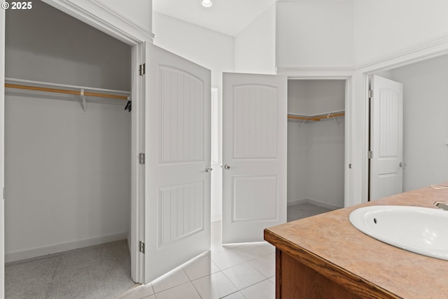 1249 Zebrawood St, Florence, OR 97439 - bathroom with vanity, a walk in closet, baseboards, and tile patterned flooring