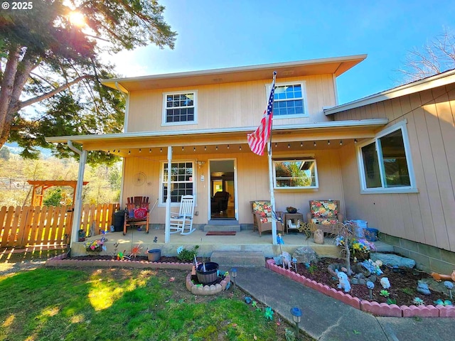 view of front facade featuring a patio area and fence