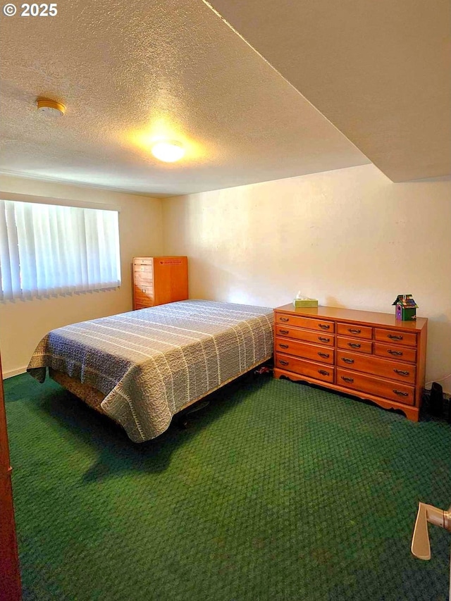 bedroom with dark colored carpet and a textured ceiling