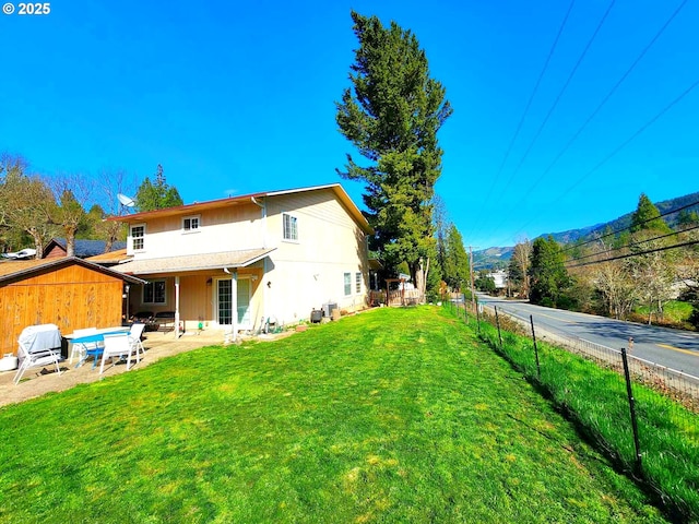 view of yard with a patio area, a mountain view, and fence