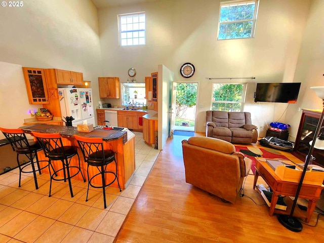 100 Canyon View St, Canyonville, OR 97417 - kitchen with white appliances, a towering ceiling, a sink, a kitchen breakfast bar, and brown cabinetry