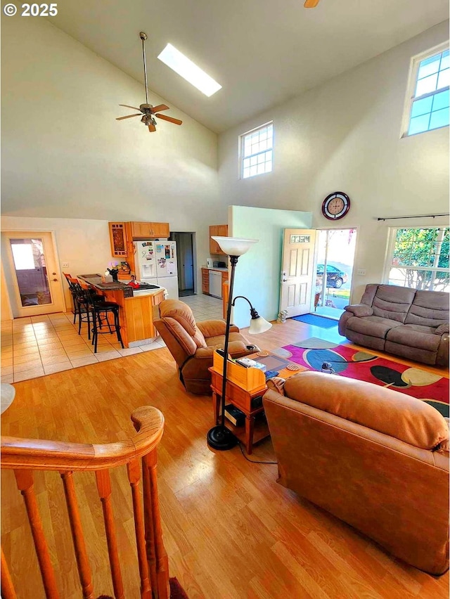 living room with high vaulted ceiling, light wood finished floors, and ceiling fan