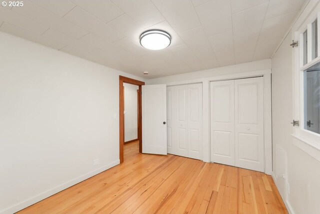 2517 Wild River Dr, Roseburg, OR 97470 - unfurnished bedroom featuring two closets, baseboards, and light wood-style floors