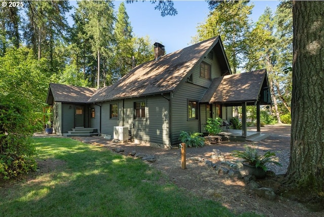 2517 Wild River Dr, Roseburg, OR 97470 - back of house featuring roof with shingles, a chimney, central air condition unit, a patio, and a lawn