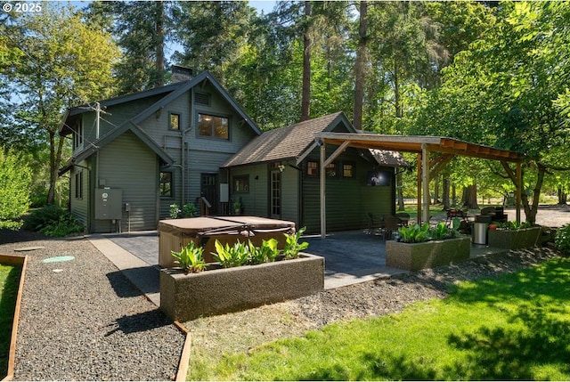 2517 Wild River Dr, Roseburg, OR 97470 - rear view of property featuring a hot tub, a patio area, and a chimney