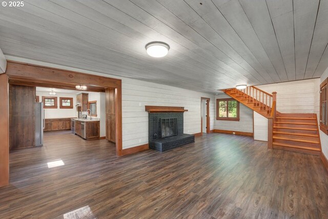 2517 Wild River Dr, Roseburg, OR 97470 - unfurnished living room featuring stairs, wooden walls, a fireplace, and dark wood-style floors