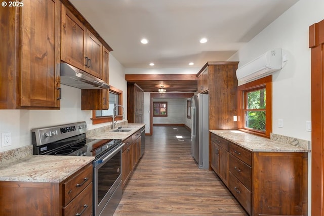 2517 Wild River Dr, Roseburg, OR 97470 - kitchen featuring dark wood-style flooring, under cabinet range hood, a wall mounted AC, a sink, and stainless steel appliances