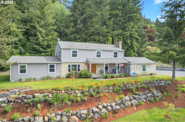 950 N Shasta Way, Clatskanie, OR 97016 - view of front facade featuring covered porch, stone siding, a chimney, and a front yard