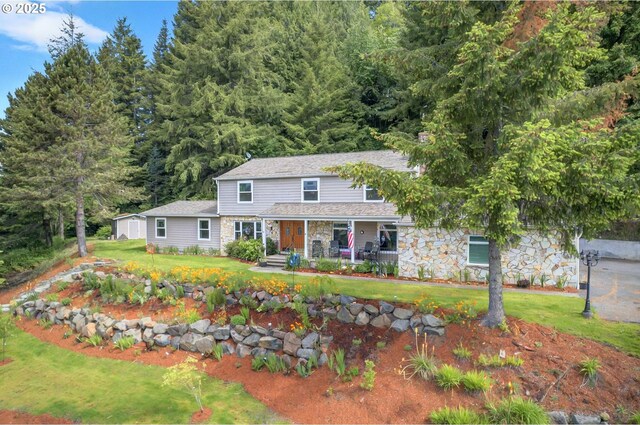 950 N Shasta Way, Clatskanie, OR 97016 - view of front of home featuring a porch, stone siding, a front lawn, and a wooded view