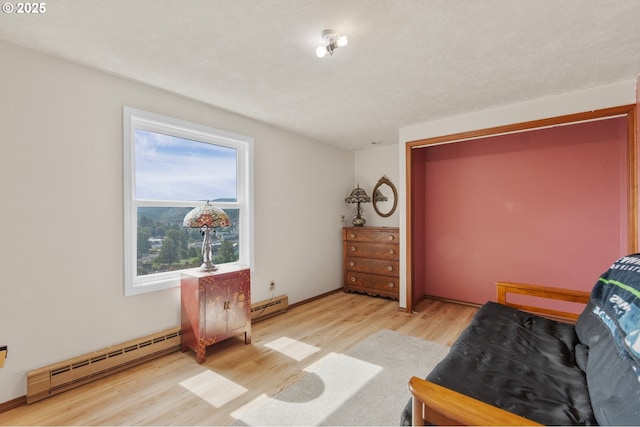 950 N Shasta Way, Clatskanie, OR 97016 - living area featuring light wood-style floors, baseboard heating, and a baseboard radiator