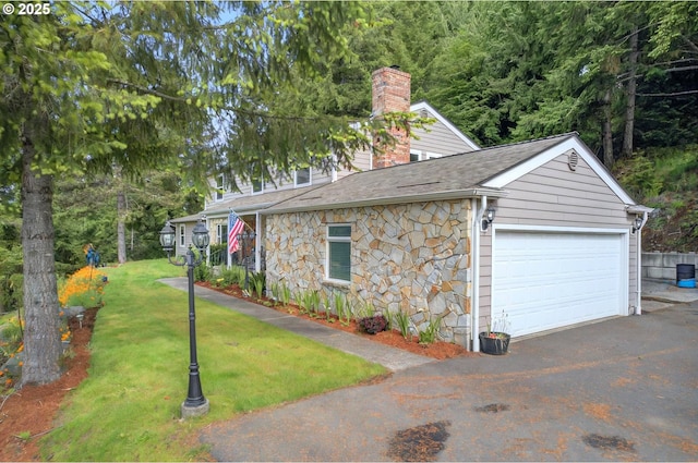 950 N Shasta Way, Clatskanie, OR 97016 - view of side of property with a chimney, a garage, stone siding, a yard, and roof with shingles