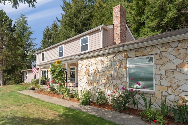 950 N Shasta Way, Clatskanie, OR 97016 - view of side of property featuring stone siding, a chimney, and a lawn