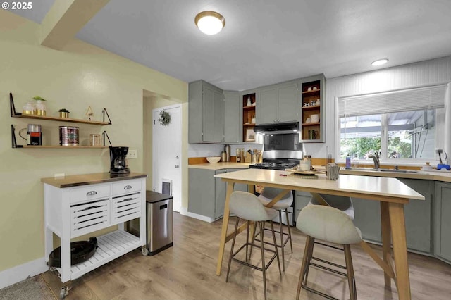1335 Centennial Blvd, Springfield, OR 97477 - kitchen featuring open shelves, stainless steel gas range, gray cabinets, under cabinet range hood, and a sink