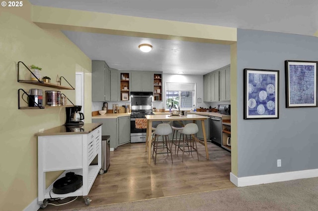 1335 Centennial Blvd, Springfield, OR 97477 - kitchen with appliances with stainless steel finishes, open shelves, gray cabinetry, baseboards, and a breakfast bar