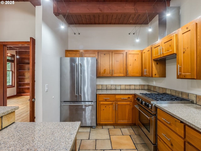 13200 NW Old Germantown Rd, Portland, OR 97035 - kitchen with premium appliances, wood ceiling with exposed beams, brown cabinetry, and light stone countertops