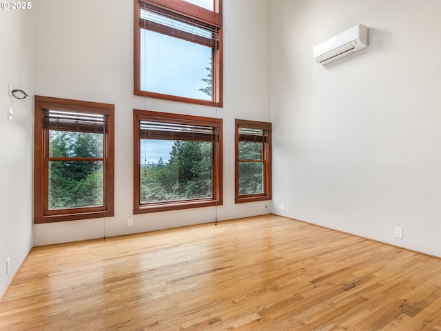 13200 NW Old Germantown Rd, Portland, OR 97035 - spare room with a wall mounted AC, a towering ceiling, and wood finished floors