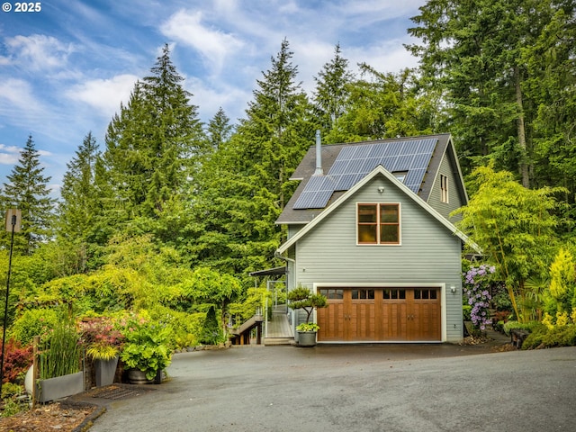 13200 NW Old Germantown Rd, Portland, OR 97035 - view of side of home with driveway, roof mounted solar panels, and a garage
