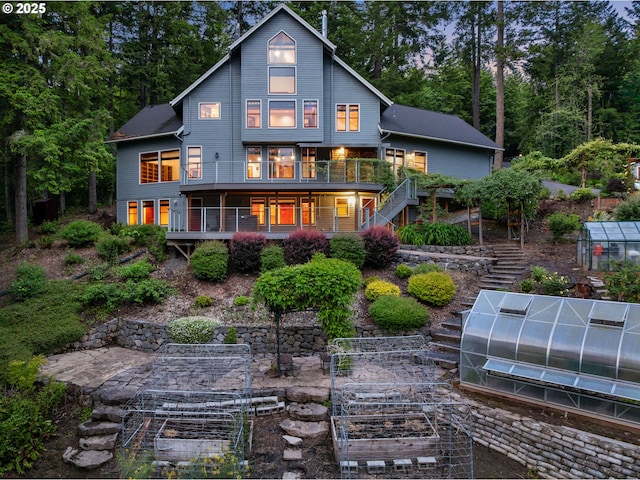 13200 NW Old Germantown Rd, Portland, OR 97035 - rear view of house featuring an exterior structure, stairway, an outbuilding, and a vegetable garden
