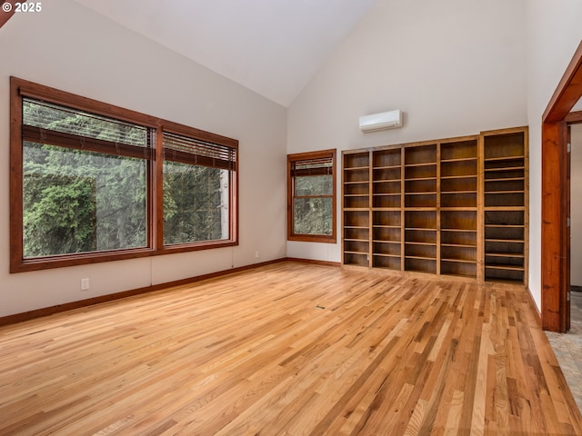 13200 NW Old Germantown Rd, Portland, OR 97035 - unfurnished room with a wall mounted AC, high vaulted ceiling, light wood-style floors, and baseboards